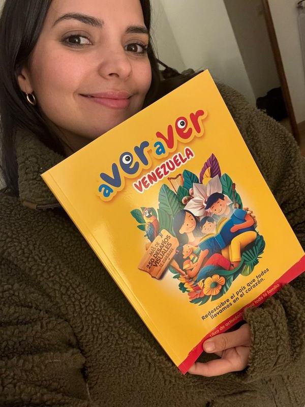 Una mujer sonríe mostrando la portada del libro